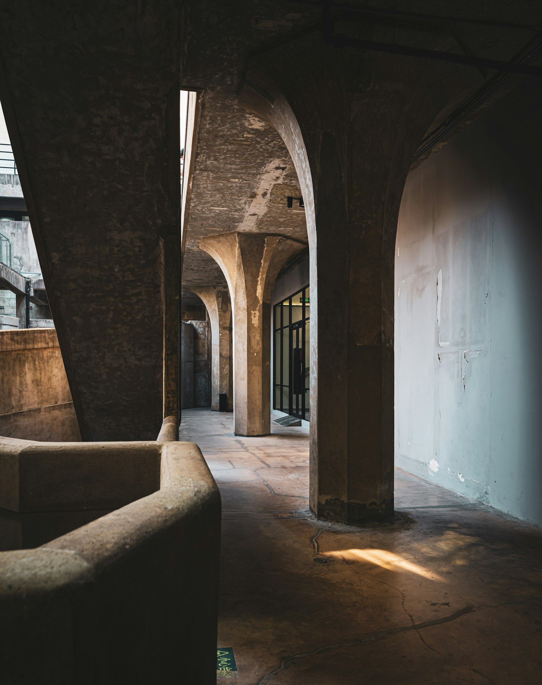 Galerie rythmée par des arches de béton